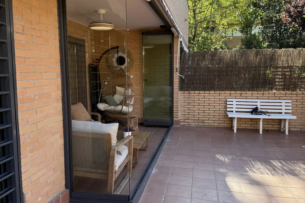 Cortina de cristal corredera cerrando un porche de vivienda unifamiliar