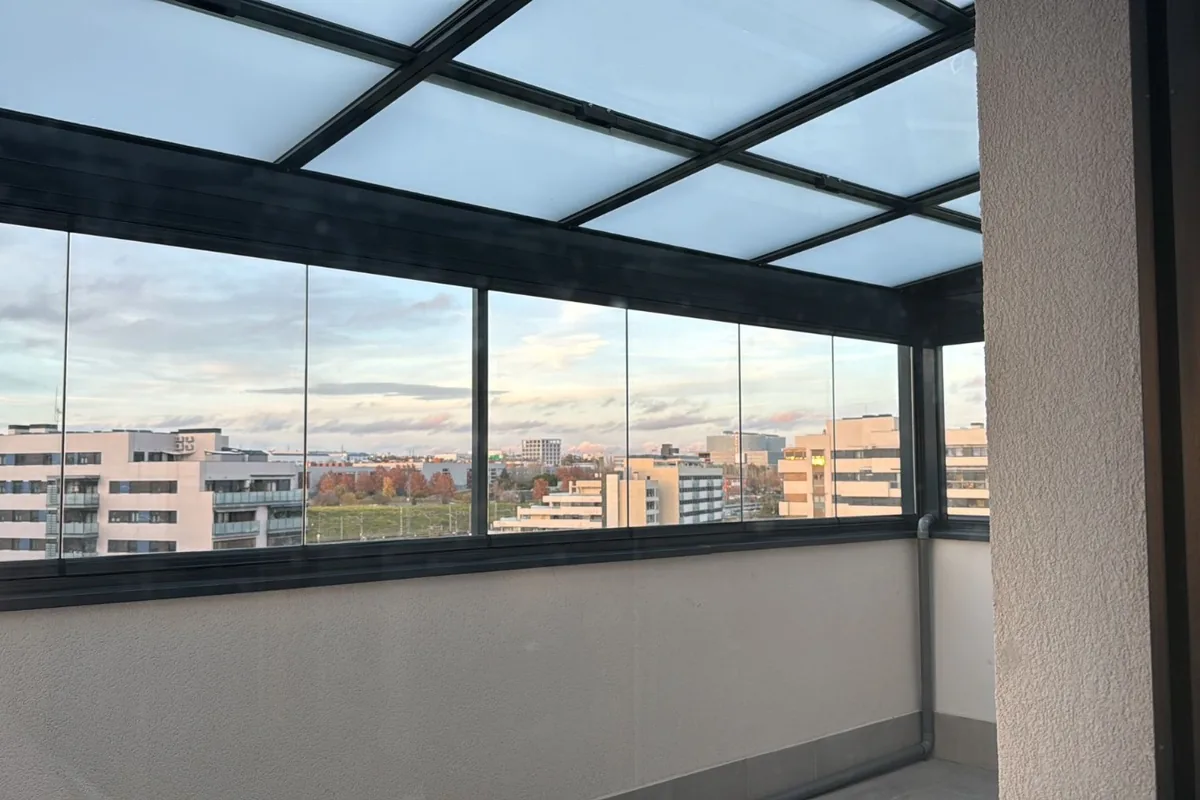 Techo de cristal fijo sobre terraza con vistas panorámicas a la ciudad