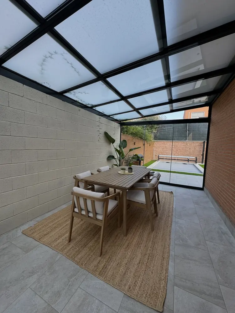 Paso acristalado del patio con salida al jardín trasero de una vivienda de Madrid