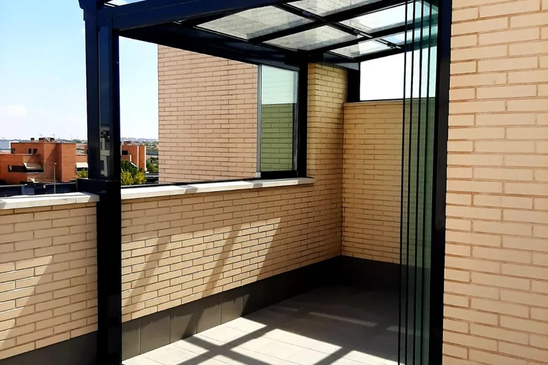 Techo de cristal fijo en esquina de terraza con vistas a viviendas adosadas