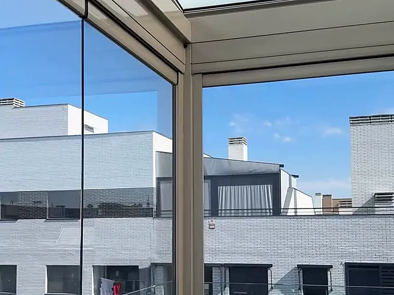 Esquina de una terraza acristalada con cortina de cristal corredera en Madrid