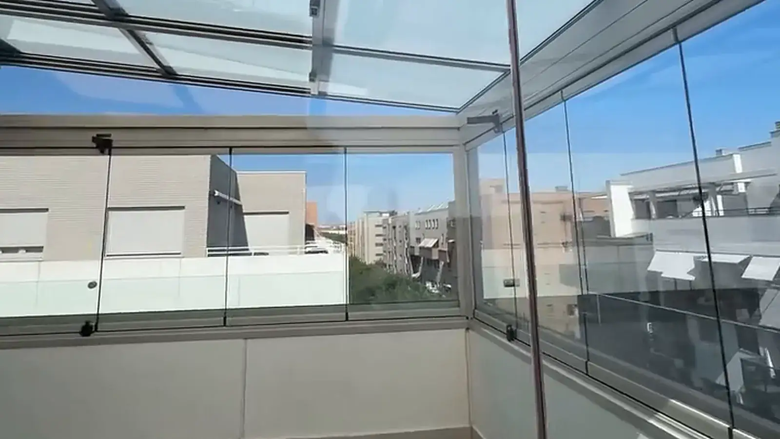 Cortina de cristal corredera abierta en la terraza de una vivienda de Madrid