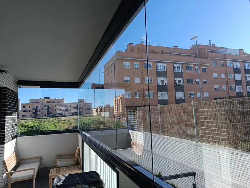 Balcón de una vivienda de la Comunidad de Madrid cerrado con cortinas de cristal