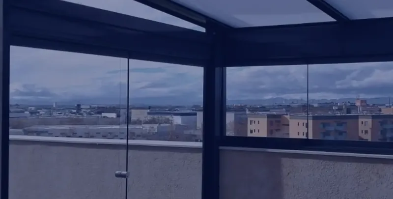 Terraza cerrada con cortinas de cristal al atardecer en Madrid