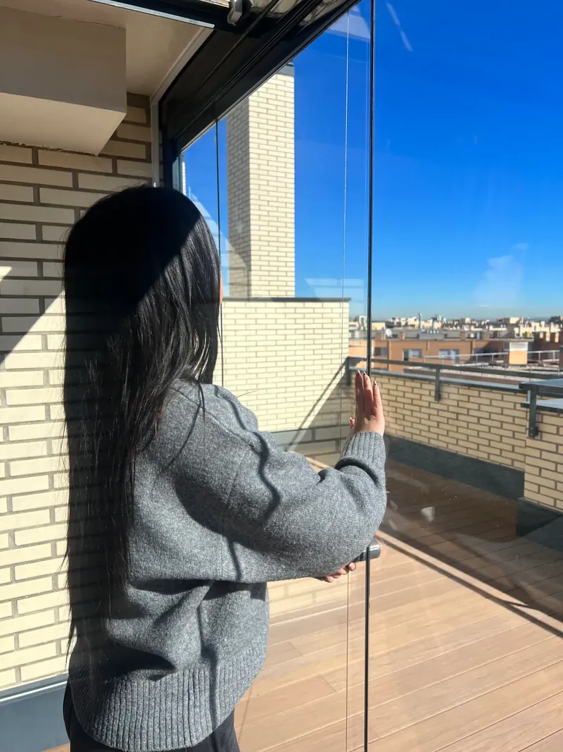 Cortina de cristal abierta en la terraza de un ático de Madrid
