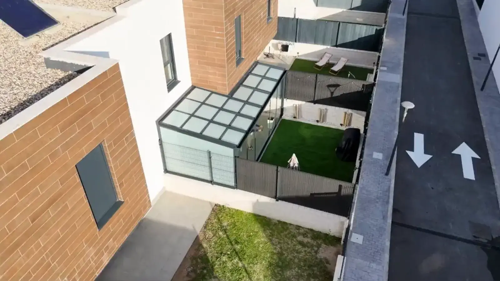 Vista aérea de una vivienda unifamiliar en Madrid con un cerramiento de cristal y techo acristalado junto al jardín