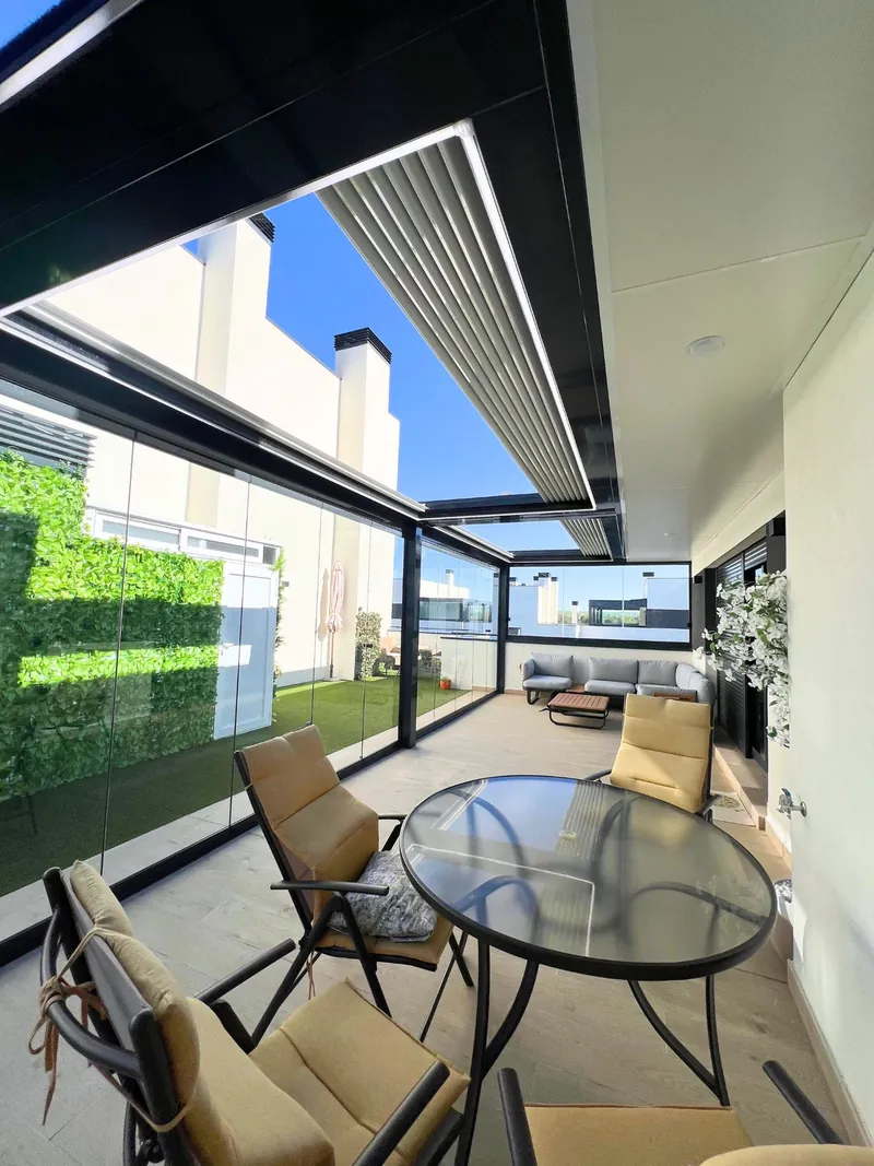 Pérgola bioclimática con lamas orientables sobre un comedor exterior en Madrid