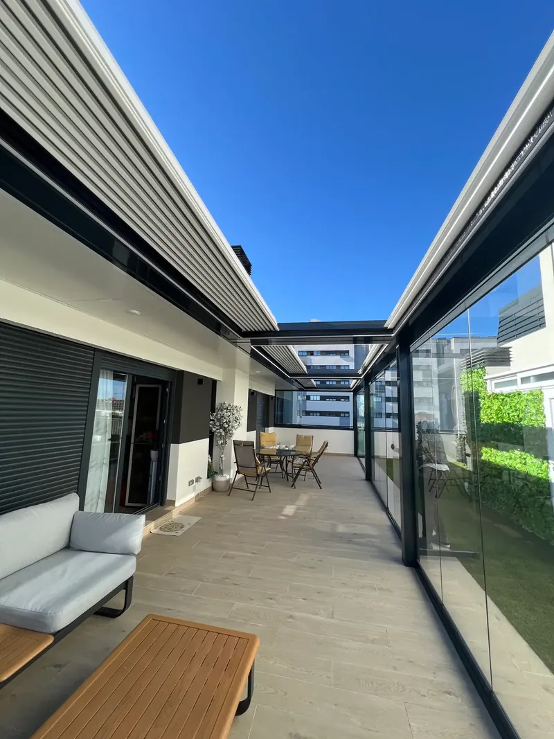 Pérgola bioclimática y cortinas de cristal en la terraza de un ático de Madrid