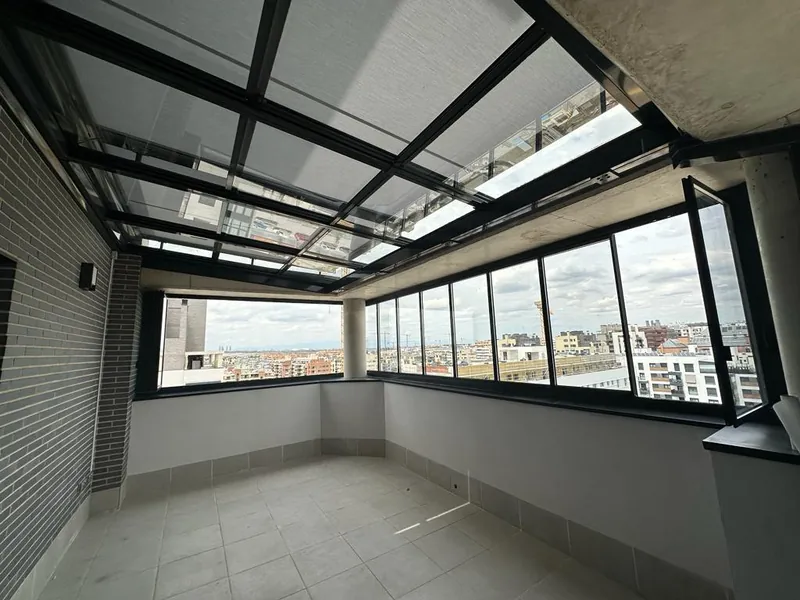 Techo de cristal y ventanal corredero en la terraza de un ático de Madrid