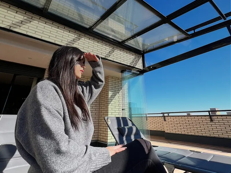 Techo de cristal móvil recogido sobre la terraza de un ático de Madrid, con la cortina de cristal abierta