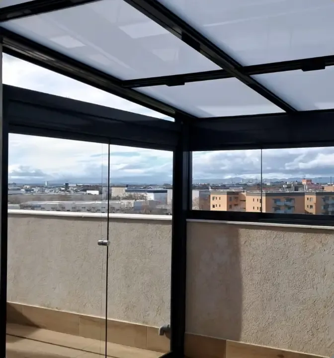 Techo con calles de panel sándwich y cortinas de cristal en una terraza de Madrid